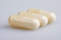 Transparent gelatin capsules with probiotics powder on white background.