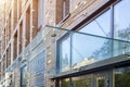 Transparent glass awning over front door of multistory brick apartment building