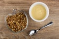 Transparent bowl with muesli, jar with yogurt, teaspoon on table. Top view Royalty Free Stock Photo