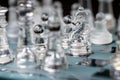 Transparent glass chess on dark background, selective focus on horse piece, close-up Royalty Free Stock Photo