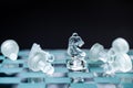 Transparent glass chess on dark background, selective focus on horse piece, close-up Royalty Free Stock Photo