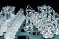 Transparent glass chess pieces on dark background. Leadership and strategy concept, selective focus Royalty Free Stock Photo