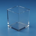 Transparent glass cube with sharp, polished edges sits on a smooth, reflective blue Royalty Free Stock Photo