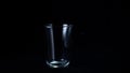 Transparent glass cup on black  background. Frame. Glass for tea stands empty glint from faint white light on Royalty Free Stock Photo