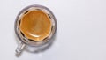 A transparent glass cup with creamy espresso, the cream of the coffee is a roasted brown and resembles the beans of the toasted co Royalty Free Stock Photo