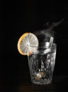 Transparent glass cup with swell the boiling water into it. The vapor from the top. Black background. Royalty Free Stock Photo