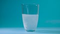 Transparent glass cup of water drops analgin tablet