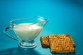 Transparent glass gravy boat with milk and cookies close-up Royalty Free Stock Photo