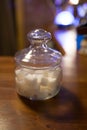 Transparent glass jar with white sugar on the table