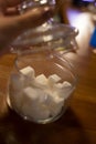 Transparent glass jar with white sugar on the table