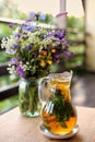 Transparent glass jug with fruit tea on a background of wildflowers, selective focus Royalty Free Stock Photo
