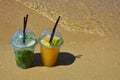 a glass of lemonade with a straw on the seashore, a sunny beach, summer vacation. background for the design. Royalty Free Stock Photo