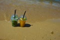 a glass of lemonade with a straw on the seashore, a sunny beach, summer vacation. background for the design. Royalty Free Stock Photo