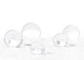 Transparent glass orbs with white snow on isolated white background.