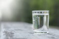Transparent glass with pure mineral water on a green natural blurred background. outdoor Royalty Free Stock Photo