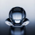 A transparent glass sphere rests on a smooth, reflective surface with a brushed metal texture. The Royalty Free Stock Photo