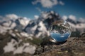 Transparent glass sphere and snow-capped peaks in the background Royalty Free Stock Photo