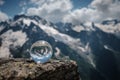 Transparent glass sphere and snow-capped peaks in the background Royalty Free Stock Photo