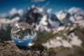 Transparent glass sphere and snow-capped peaks in the background Royalty Free Stock Photo