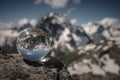 Transparent glass sphere and snow-capped peaks in the background Royalty Free Stock Photo