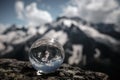 Transparent glass sphere and snow-capped peaks in the background Royalty Free Stock Photo