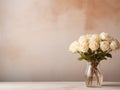 Transparent glass vase with bouquet of white roses on table and empty wall Royalty Free Stock Photo