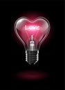 Transparent glowing heart-shaped light bulb on a dark background with the word Love instead of a tungsten filament. Highly Royalty Free Stock Photo