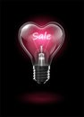 Transparent glowing heart-shaped light bulb on a dark background with the word Sale instead of a tungsten filament. Highly Royalty Free Stock Photo