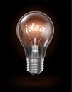 Transparent glowing light bulb on a dark background with the word IDEA instead of a tungsten filament. Highly realistic Royalty Free Stock Photo