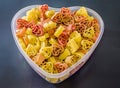 Transparent heart shape vase (bowl) filled with colored (red, yellow an orange) heart shape pasta, colored degradee background Royalty Free Stock Photo