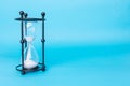 Transparent hourglass, Blue background. On the left. Copy, text space Royalty Free Stock Photo