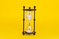 Transparent hourglass. Yellow background. In the center. Copy, text space Royalty Free Stock Photo