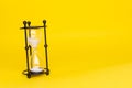 Transparent hourglass, Yellow background. On the left. Copy, text space Royalty Free Stock Photo