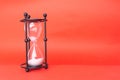 Transparent hourglass, Red background. On the left. Copy, text space Royalty Free Stock Photo