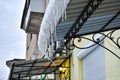 Transparent icicles from the frozen melting snow will rise on the roof of the balcony. Royalty Free Stock Photo