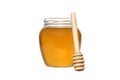 A transparent jar with honey and a wooden spoon stands on a white isolated background. Royalty Free Stock Photo