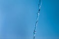 Transparent jet of water against a blue background. Cold water, ice water. The glare of light is reflected in the flow of water Royalty Free Stock Photo