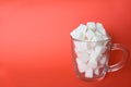 Transparent mug full of refined white sugar cubes on red background. Copy space Royalty Free Stock Photo