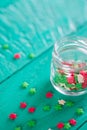 Transparent open glass jar with colorful confectionery powder in
