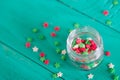 Transparent open glass jar with colorful confectionery powder in
