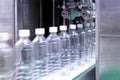 Transparent plastic bottles on the conveyor belt moving very fast into water filling machine in the drinking water factory. Royalty Free Stock Photo