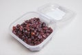 Transparent plastic bowl full of dried blueberry