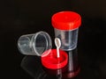 Transparent plastic containers for analysis, with red lids, on a dark background Royalty Free Stock Photo