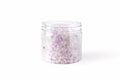 Transparent plastic jar with large flakes of violet lavender marine dead sea salt isolated on clean white background Royalty Free Stock Photo