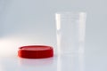 Transparent plastic jar with a red lid on a white background. for analysis Royalty Free Stock Photo