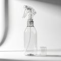 Transparent plastic spray bottle with a clear trigger nozzle, placed on a white surface. Royalty Free Stock Photo