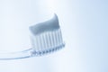 Transparent plastic toothbrush with white toothpaste on a light blue background Royalty Free Stock Photo