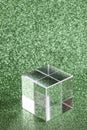transparent podium for product display on green glittering background.