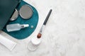 Transparent powder, makeup brush, pocket mirror, facial serum and hand cream on marble table and copy space, top view