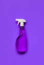 Transparent purple spray bottle with window cleaner on purple background. Royalty Free Stock Photo